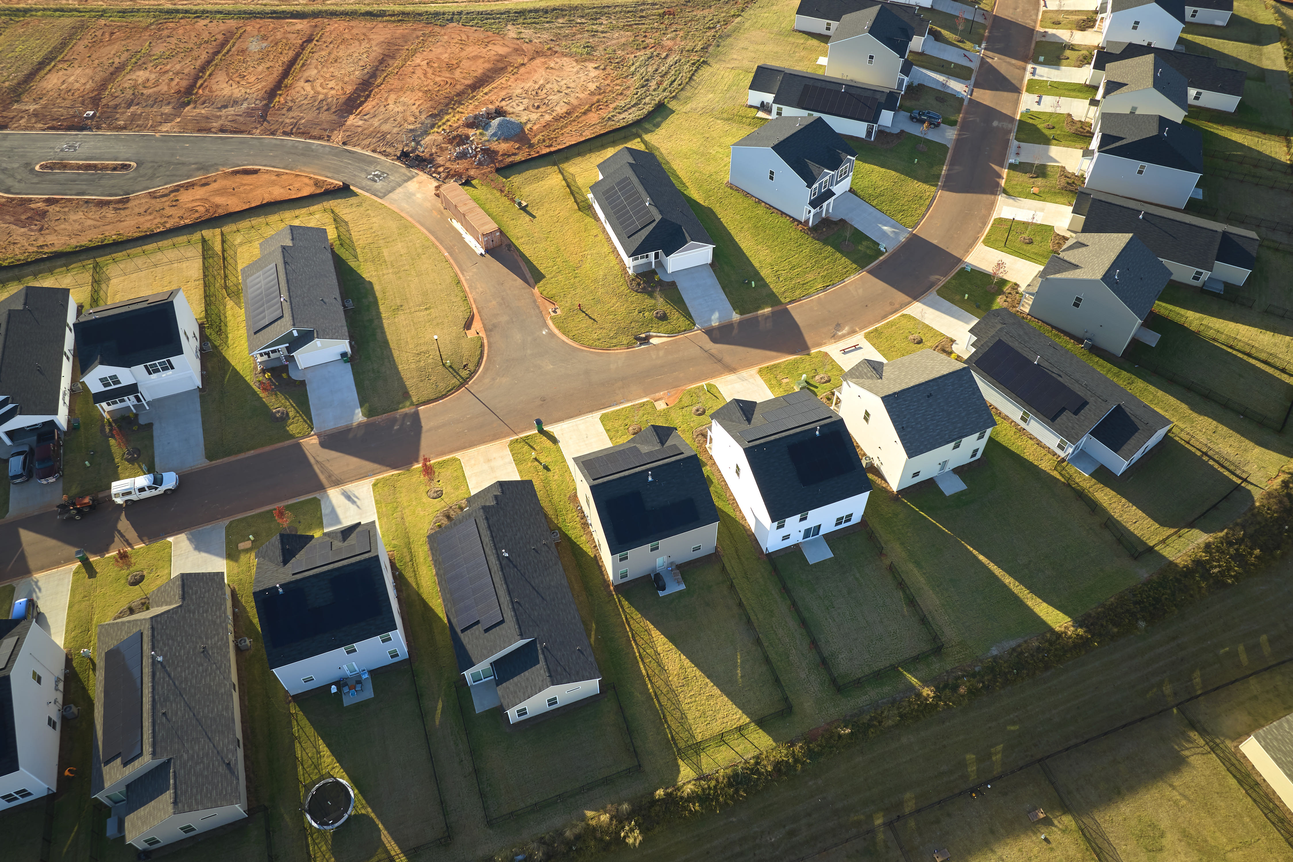 Aerial view of a finished housing development at golden hour — placeholder photography.