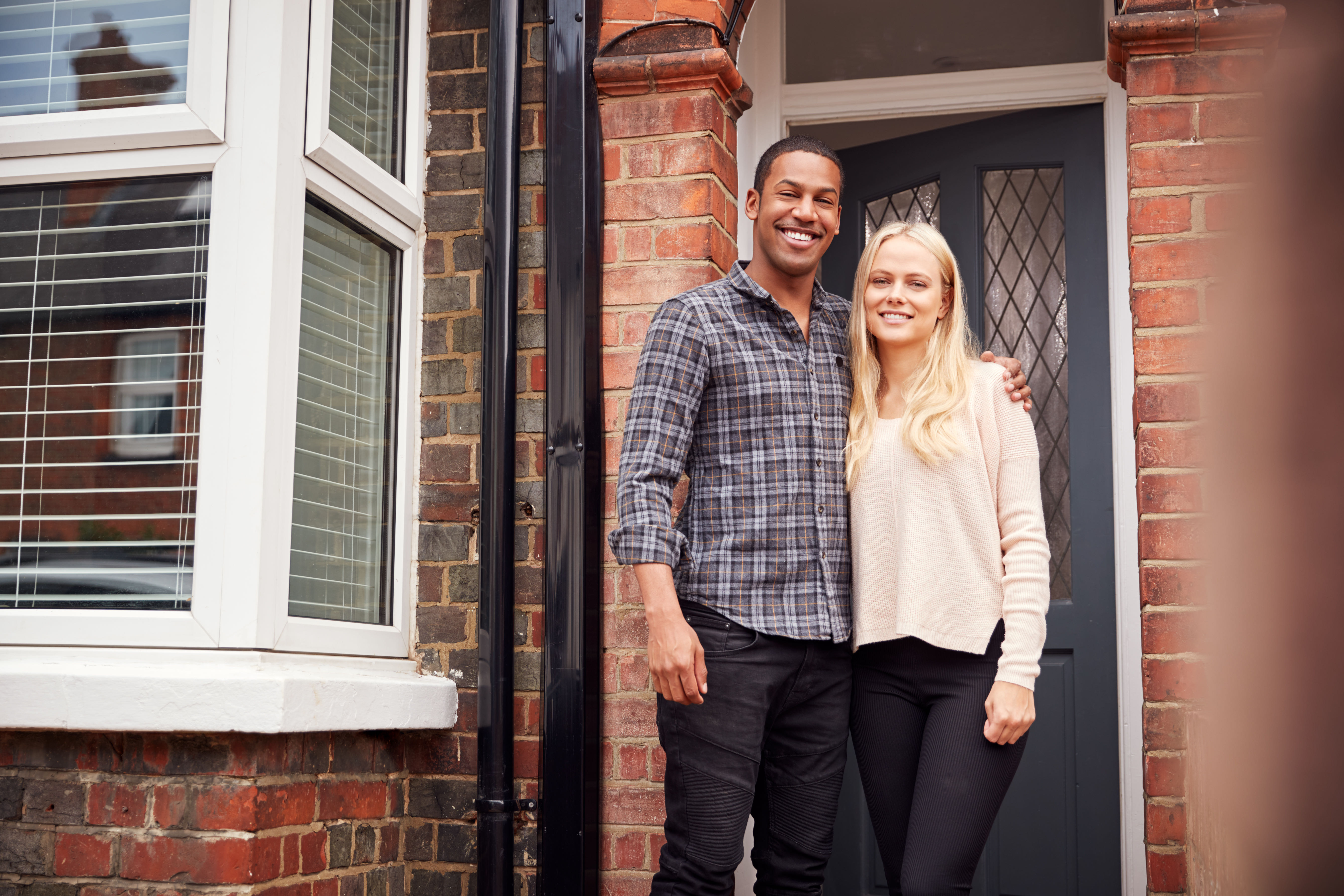 A couple at the door of their new home.